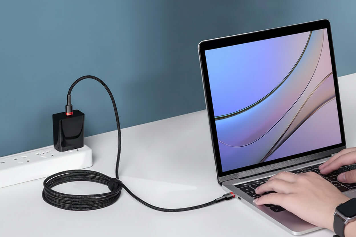 Baseus 100W USB-C fast charging cable connected to a laptop for fast data transfer and charging.